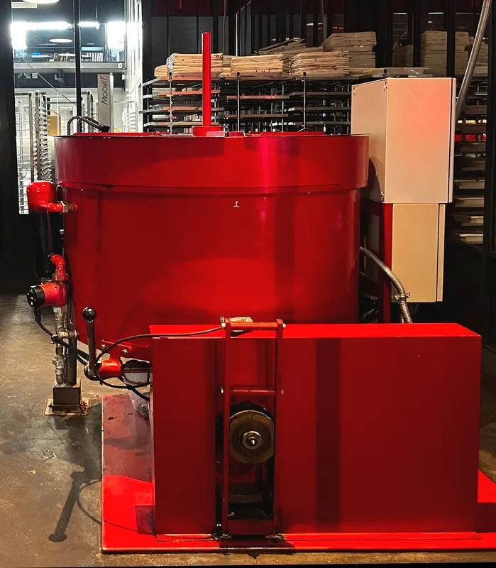 A red chocolate conching machine on display